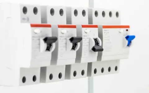 Szereg wyłączników nadprądowych. Na jednym z nich widoczny dobór bezpiecznika do mocy wzór: 25A, U=230V.