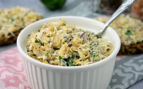 Pyszna pasta z makreli z cebulką i natką pietruszki, podana w białej miseczce, gotowa do smarowania.