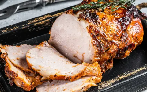 Soczysty schab z piekarnika, idealnie upieczony, z chrupiącą skórką i ziołami. Pokrojony w plastry, gotowy do podania.