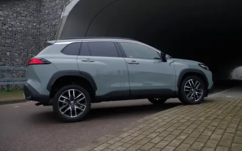 Szary Toyota Corolla Cross hybrydowa stoi na tle tunelu.