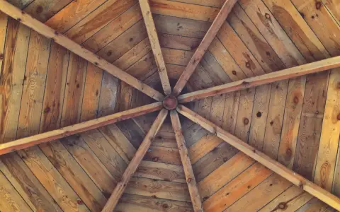 Estructura radial de vigas de madera que se unen en el centro, formando unos techos de madera rústicos y acogedores.