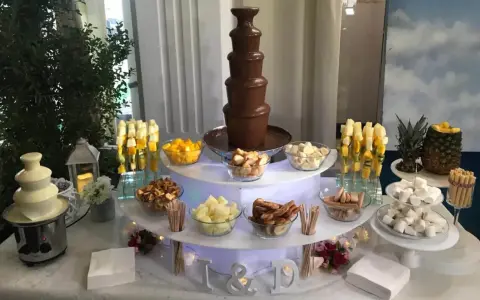 Ideas mesa dulce: fuente de chocolate blanco y negro, frutas, malvaviscos y galletas para una celebración.