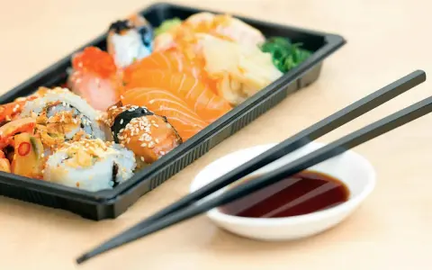 En låda med sushi och sashimi, redo att ätas. Perfekt för den som vill **springa efter mat** utan att kompromissa med smaken.