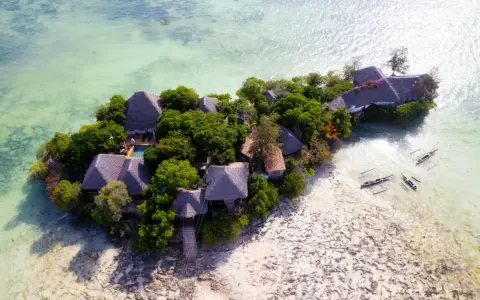Rajska wyspa z chatkami i basenem, otoczona turkusową wodą. Idealne zanzibar atrakcje dla szukających spokoju.