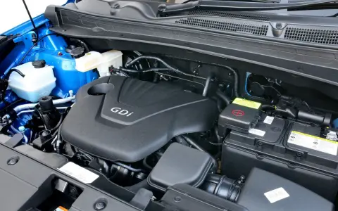 Silnik GDI w Kia Sportage (2015) z widocznym akumulatorem i płynami.