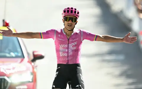 Richard Carapaz feiert mit ausgestreckten Armen einen Sieg.