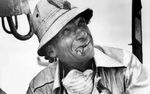 Un uomo con un sigaro in bocca e un cappello da esploratore, in un'immagine iconica di un film di Samuel Fuller.