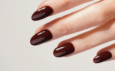 Mani curate con unghie laccate di un intenso color **baby boomer marrone**, lucide e perfette.