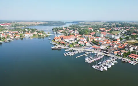 Malownicze miasteczko z mariną pełną żaglówek i domów z czerwonymi dachami. Idealne miejsce na letni wypoczynek, jakbyśmy byli na plaży w Mikołajkach.