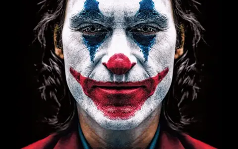 Intensywny joker makijaż z niebieskimi łzami i czerwoną, uśmiechniętą twarzą.