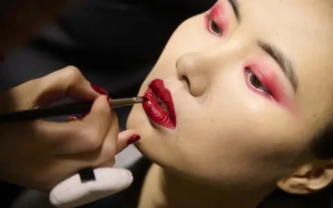Labbra rosse intense e un trucco audace sugli occhi creano un look da sirena.