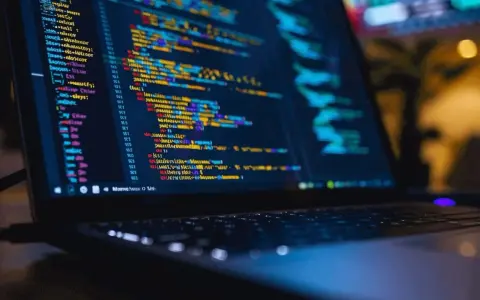 Laptop z kolorowym kodem, gdzie niektóre linie są przekreślone równa się, sugerując błędy lub zmiany w programie.