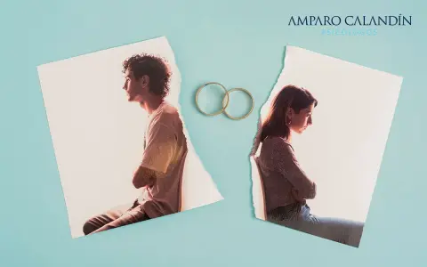 Dos fotos rasgadas de una pareja, separadas por dos anillos de boda, simbolizan un matrimonio infeliz.