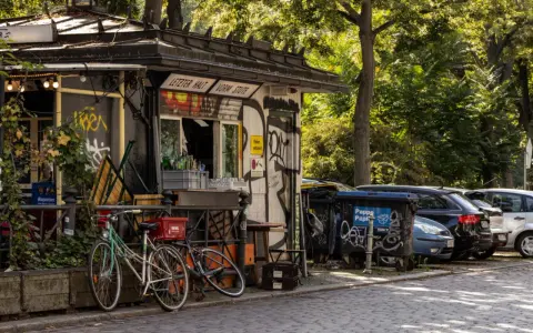 Ein Kiosk in Berlin Kreuzberg mit Fahrrädern davor und Autos dahinter.