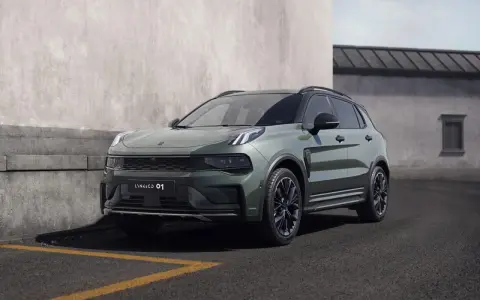 Nowoczesny, zielony SUV Lynk & Co 01 zaparkowany przy betonowej ścianie.