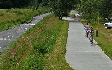 Rowerzyści cieszą się malowniczymi trasami rowerowymi w Muszynie, jadąc wzdłuż rzeki.
