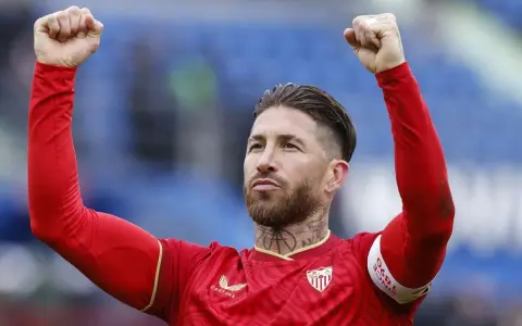 Sergio Ramos w czerwonej koszulce z podniesionymi pięściami, świętuje zwycięstwo. To właśnie tam, gdzie gra Sergio Ramos, czuć emocje!