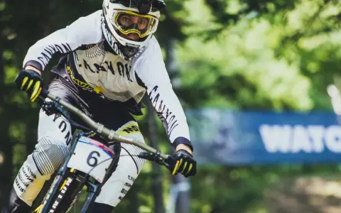 Downhill-Fahrer Mark Wallace in voller Fahrt, mit Helm und Brille, bereit für die nächste Herausforderung.