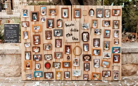 Un original seating plan boda con muchas fotos de parejas en marcos de madera.