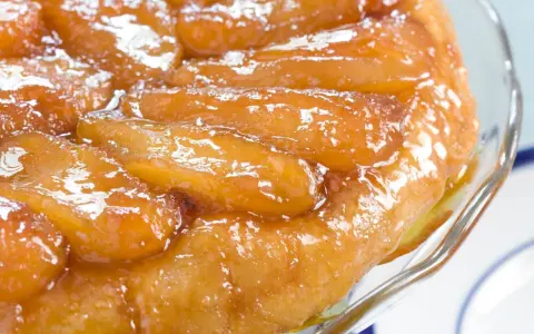 Une délicieuse tarte tatin aux pommes caramélisées, servie dans un plat en verre.
