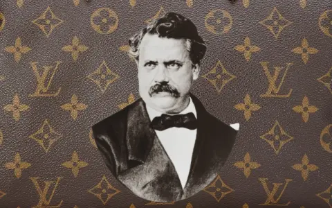 Ritratto in bianco e nero di Louis Vuitton, con il suo iconico monogramma sullo sfondo.