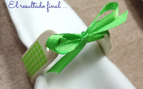 Servilleteros caseros originales: un detalle de madera con cinta verde brillante y patrón de cuadros, atado a una servilleta blanca.