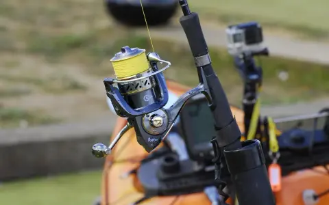 Wędkarski sprzęt gotowy do połowów suma. Kołowrotek z żółtą żyłką i kamerka GoPro czekają na przygodę.