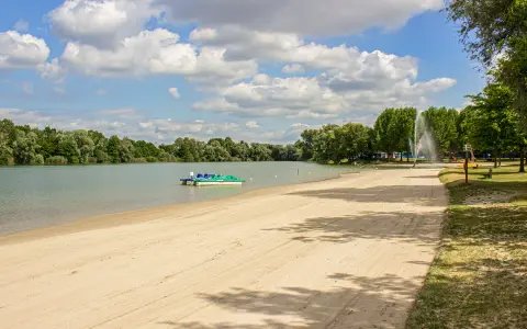 Sommerliche Idylle am Baggersee: Sandstrand, Tretboote und eine Fontäne laden zum Entspannen ein. Hier lässt sich das Leben in Karlsruhe genießen.