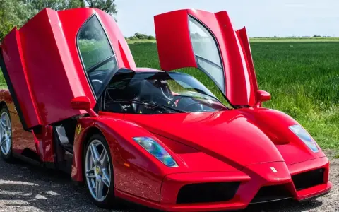 Czerwone Ferrari Enzo z otwartymi drzwiami, marzenie wielu. Zastanawiasz się, ferrari enzo ile kosztuje?