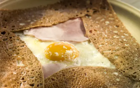 Crêpe bretonne garnie d'un œuf au plat, de jambon et de fromage. Un délice de crêpes françaises.