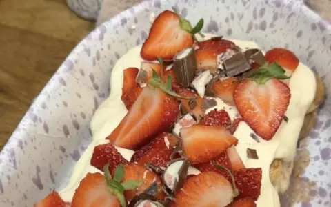 Ein köstliches Erdbeer Tiramisu, üppig belegt mit frischen Erdbeeren, Schokoladenstückchen und cremiger Mascarpone.