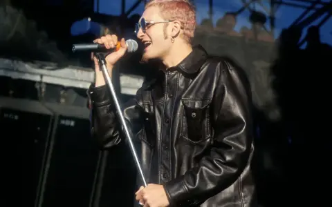 Layne Staley w skórzanej kurtce śpiewa do mikrofonu. Jego śmierć wciąż porusza fanów.