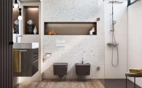 Nowoczesna, wąska łazienka z prysznicem. W centrum uwagę przyciąga ściana z terazzo, a obok niej wiszące toalety i bidet.