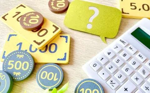 Jouets représentant des billets et des pièces, avec une calculatrice et un point d'interrogation. Une aide visuelle pour comprendre la fiscalité PEL.