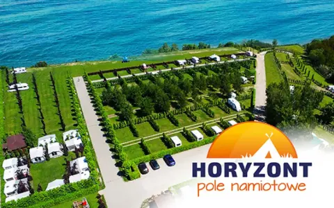 Piękne pole namiotowe z widokiem na morze. Kampery i przyczepy kempingowe rozstawione na zielonych parcelach.