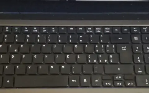 Klawiatura laptopa z włoskim układem klawiatury. Widoczne klawisze z literami, cyframi i symbolami, w tym € i accented vowels.