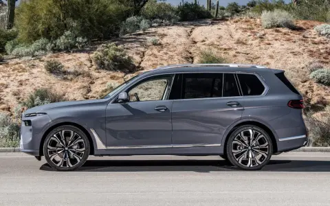Szary BMW X9 na tle pustynnego krajobrazu. Elegancki SUV z chromowanymi detalami i masywnymi felgami.