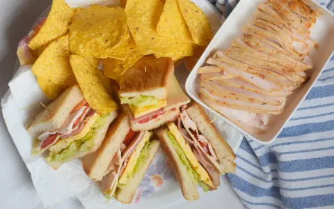 Sandwiches de fiambre de pollo casero, papas fritas y lonchas de pollo. ¡Un festín listo para disfrutar!
