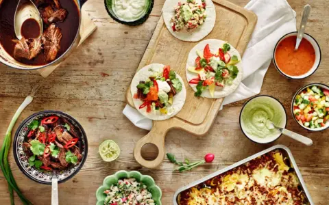 En härlig dukning med tacos, gryta med kött, salsa och guacamole. Perfekt för en mysig kväll med vin till tacos.