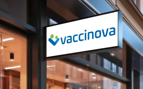Belyst skylt med logotypen "vaccinova" och två stiliserade figurer, en grön och en blå. Företaget fokuserar på vaccin i Asien.