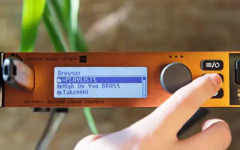 Palec naciska przycisk na urządzeniu cymatic audio uTrack 24, wyświetlającym listę odtwarzania.