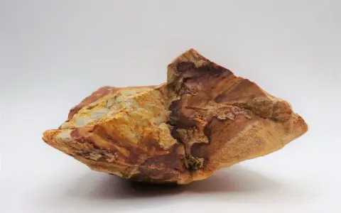 Fragmento de jaspe con vetas rojizas y ocres, mostrando sus propiedades terrosas y su belleza natural.