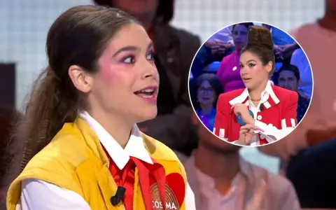 Cosima Ruiz de la Prada, con maquillaje llamativo y un chaleco amarillo, habla en un programa. En un círculo, se ve su peinado alto y chaqueta roja.