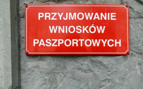 Czerwona tablica informuje o przyjmowaniu wniosków paszportowych. Czy żona może odebrać paszport męża? Sprawdź w urzędzie.