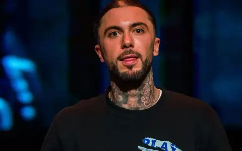 Malik Montana, mój brat, z tatuażami na szyi, w czarnej bluzie z napisem "PLAY".