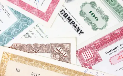 Różnorodne akcje total SA, z numerami 100 i innymi oznaczeniami, tworzą kolorowy kolaż.