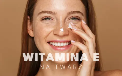Uśmiechnięta kobieta z piegami aplikuje krem pod oczy. Witamina E na twarz dla promiennej cery.