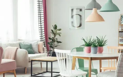 Jasne, oto opis:

Salon w stylu skandynawskim, gdzie dominują **kolory pastelowe**. Miękka sofa, różowe fotele i zielone akcenty tworzą przytulną atmosferę.