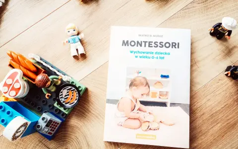 Książka "Montessori. Wychowanie dziecka w wieku 0-6 lat" obok klocków i figurek. Idealna do nauki przez zabawę.