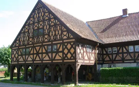 Piękny dom podcieniowy z charakterystyczną, zdobioną szachulcową fasadą i ceramicznym dachem.
